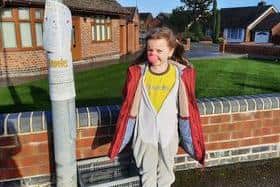 Madeleine with her lamppost note and donation box on Daisy Farm Road.