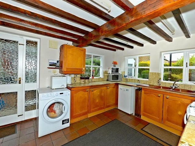The kitchen hosts space and fittings for an oven, and also space and plumbing for both a washing machine and a fridge/freezer. There are windows to the side and back of the cottage.