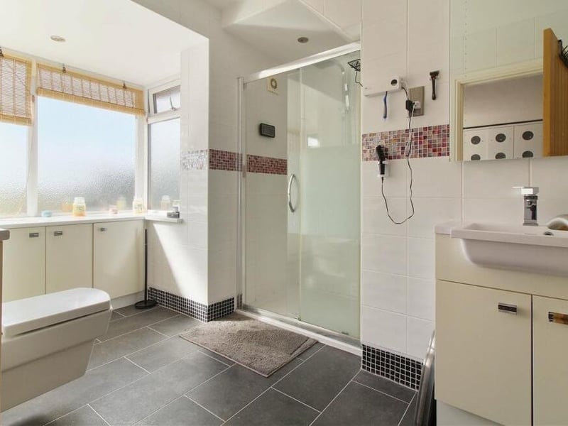 A walk-in shower cubicle is at the heart of this en suite shower room, which serves one of the two bedrooms on the first floor.