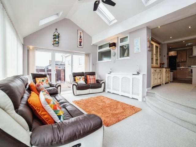 An image that shows how the family room leads from the dining area. It resembles a conservatory in that it is full of natural light.
