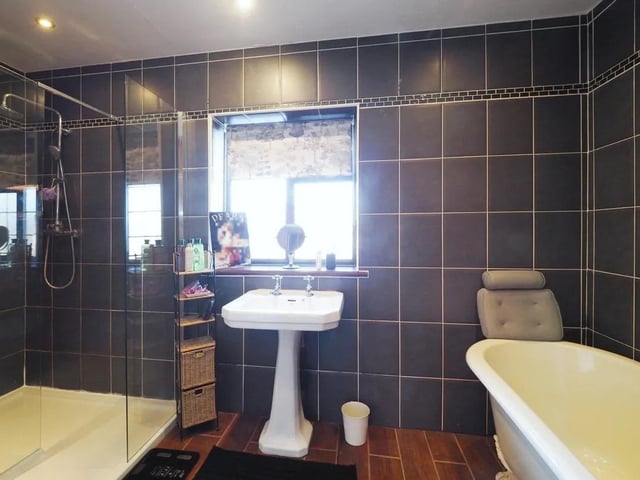 The family bathroom comprises a roll-top bath with claw feet, a pedestal wash basin, a double shower enclosure with a chrome shower over, a WC, a heated towel rail, a fitted store cupboard, an airing cupboard housing the hot water tank and a tiled floor.