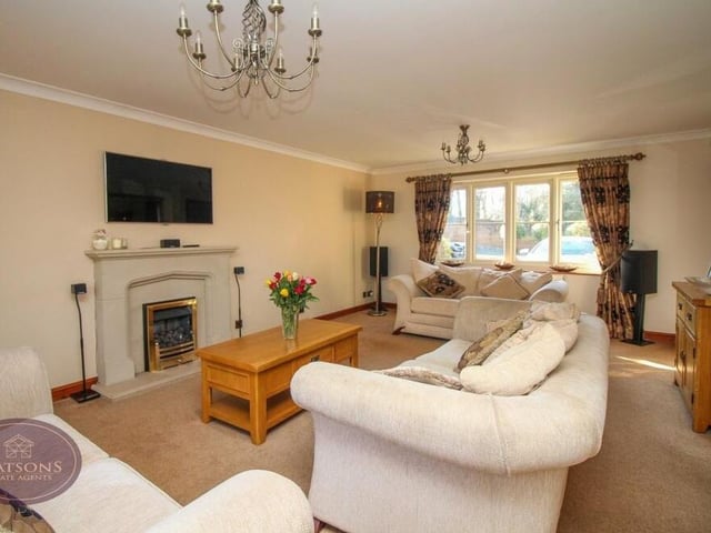 A lovely lounge features windows to the front and side, a real-flame gas fire, set within an attractive fireplace, and French doors leading to the back garden.