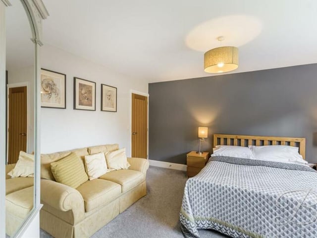 The first of five bedrooms on the first floor is this marvellous master, which even has space for a chaise lounge or sofa for additional relaxation.