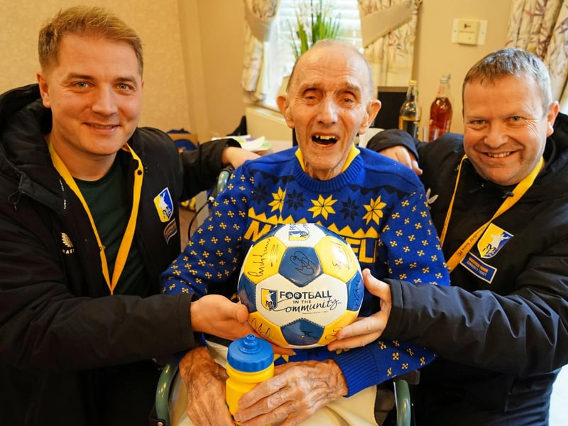 Mansfield Town Community Trust has been uniting people through sports since 1990 in Mansfield, Ashfield, and surrounding areas. Here is Keith Painter, super Stags fan, on his 90th birthday in 2024 with Michal Kasinowicz and Gary Shaw from the trust.