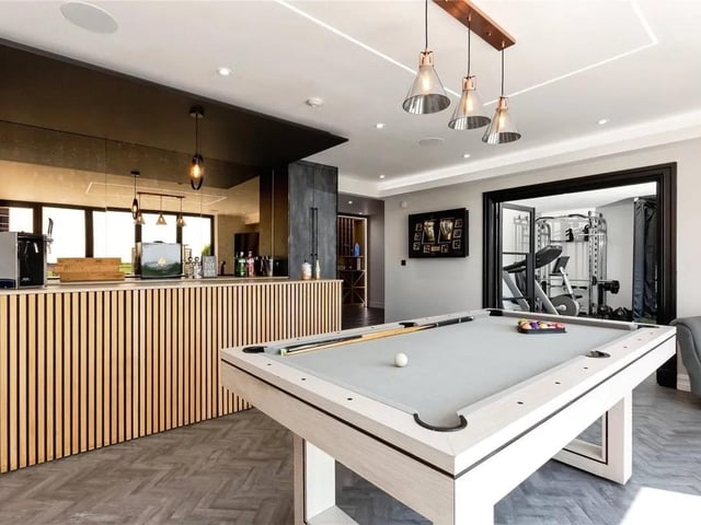A private gym provides a dedicated space for health and wellness including high specification golf simulator. The stylish bar area is a standout feature - finished with bespoke fittings, ambient lighting, and ample space for hosting.