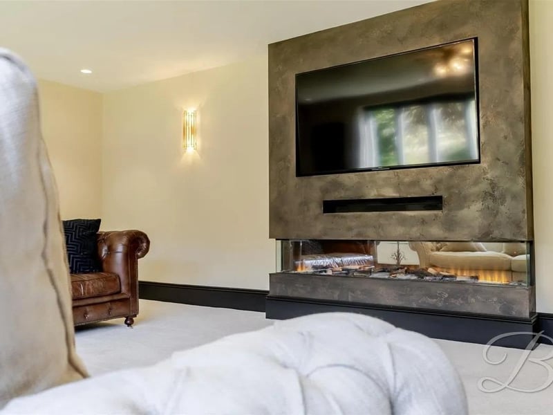 An expansive living area featuring plush carpets and a stylish feature wall that adds character to the space.