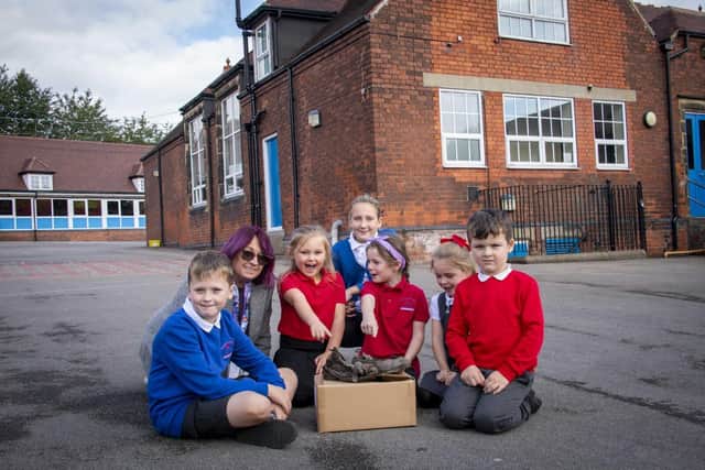 Anne Ingle (2nd left) with children in front of the building where the shoes were found.