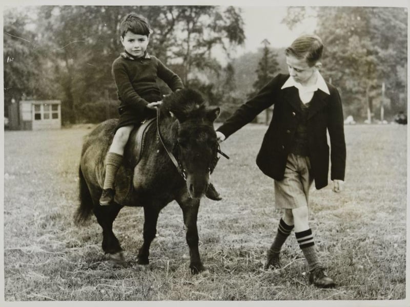 At Ashley House School, Worksop, war evacuees enjoy horse riding and fresh air. Here is Lawrence Mann, aged 5, evacuated from a bombed area in London, learning to ride a pony. He is being led by David John Walker, who is a regular pupil at the school.