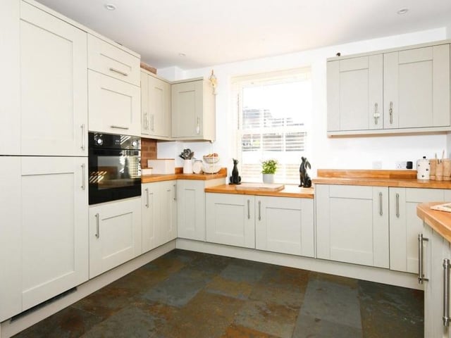 A second shot of the kitchen reveals a host of matching cabinets and units, with modern appliances. All superbly presented.