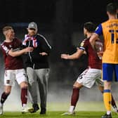 Trouble flares last week as Northampton fans run onto the pitch towards the Stags players.