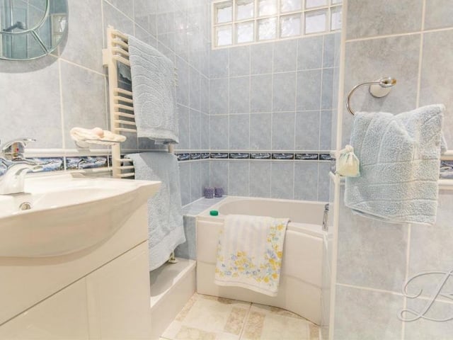 Here are the latest en suite facilities to check out at the Ravenshead property. Comprising a panelled bath, vanity unit with wash hand basin and heated towel-rail, they belong to the third bedroom.