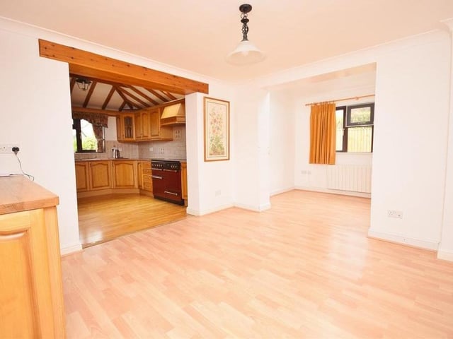 Just off the kitchen is this dining area, which is a large, practicable space that also opens into the playroom. It features wall and base units with a work surface over. The floor is laminated.