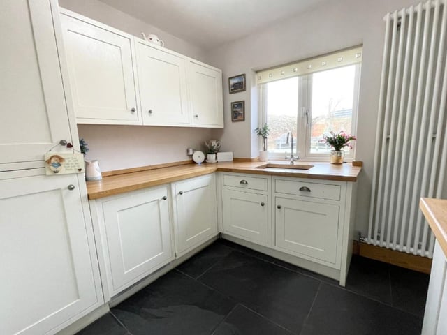 This functional utility room includes an integrated washer and drier. There are also more fitted wall and base units, solid oak worktops, a large vertical radiator and a ceramic sink with mixer tap.
