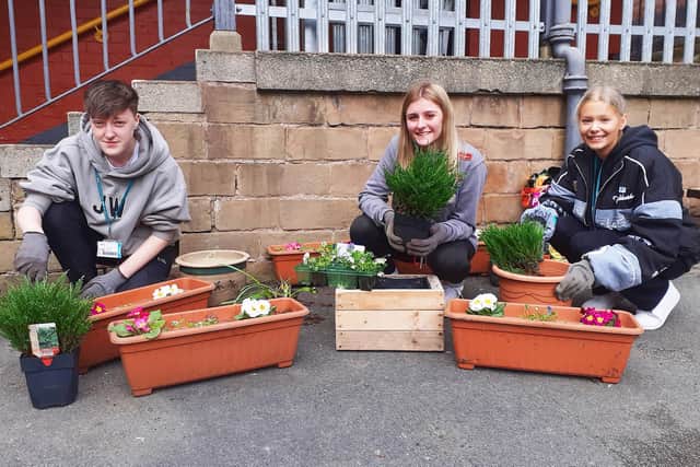 Forensic science students Chloe Gormley, Aliesha Holmes and Ruby Dennis get green fingered in the courtyard area.