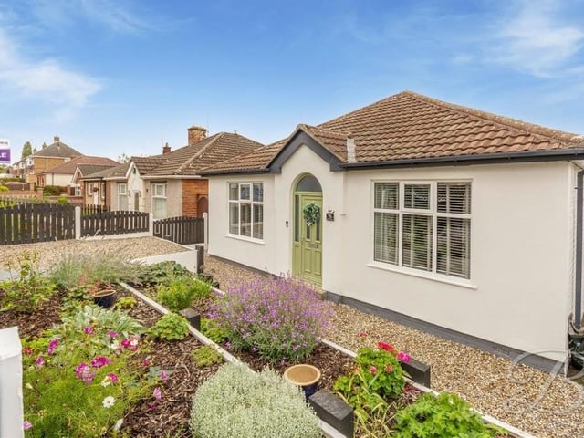 Returning to the front of the bungalow, it can be seen that the garden here is also an attractive space. It comprises a gated entrance, decorative stone and shrubbery.