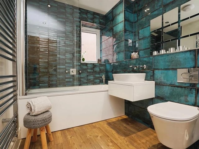 The family bathroom combines practicality and style. It features a wall-mounted toilet and a modern floating basin.