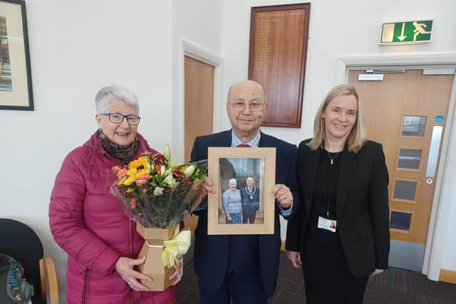 Pictured is Karen Hanson (far right) presenting some flowers to Diana Munro and a picture to Councillor Tom Munro
