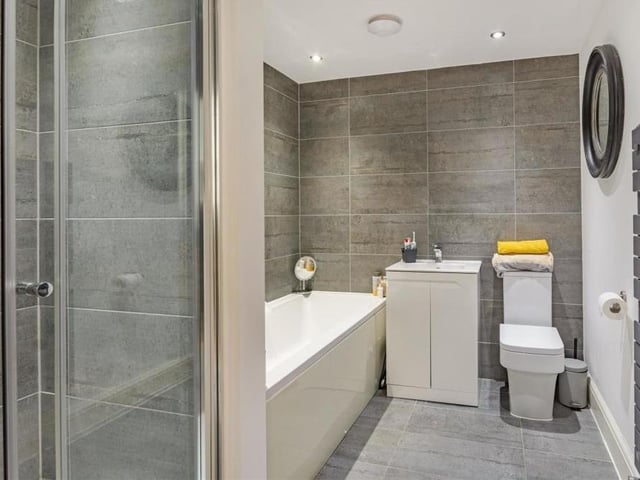 The family bathroom consists of a contemporary four-piece suite with chrome fittings. There's a panelled bath with mixer tap, separate tiled shower enclosure, vanity unit with inset wash hand basin and storage cupboard beneath, and a low-flush WC. The heated towel-rail is a bonus.