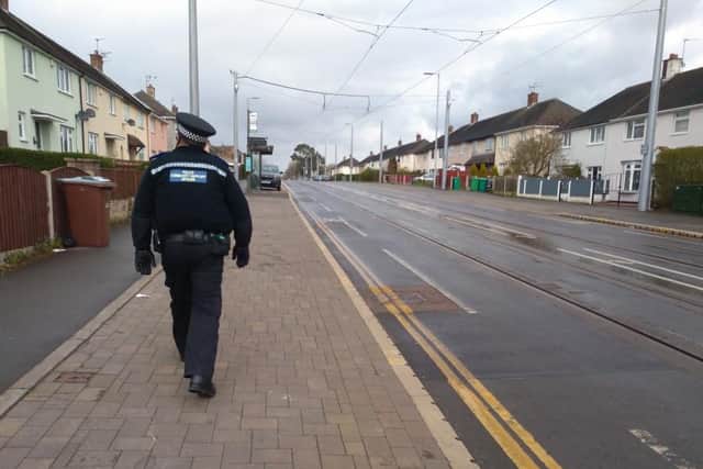 Police officer patrols street during lockdown.