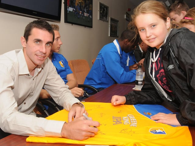 New signing John Thompson signs a shirt at Stags open day along with Amber Melling