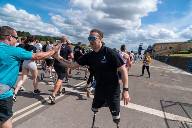 Richard Whitehead high fives participants at the start of the 2022 Run with Rich event in Nottingham.