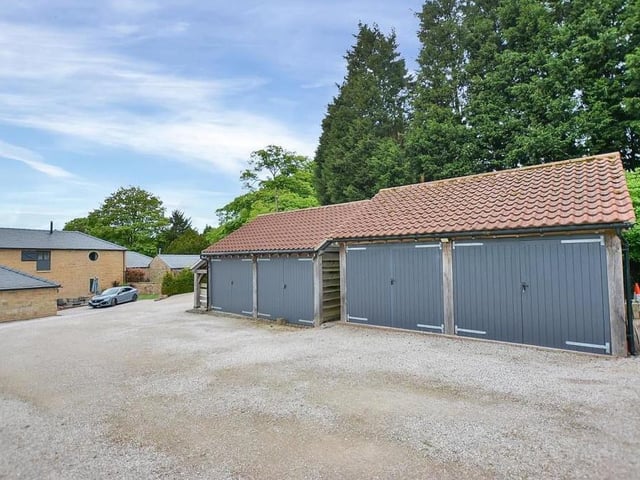 A shared gravel driveway leads to a courtyard that houses this oak-framed, detached double garage, which is equipped with power and light.