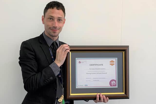 Tom Millar, deputy safeguarding lead and mental health lead at Queen's Elizabeth Academy, with the Young Carers in School’ Award.