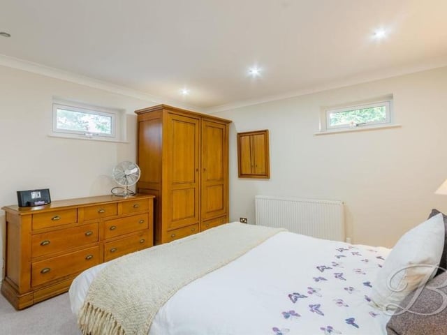 Bedroom number two is an excellent size, with space for drawers and wardrobes. The floor is carpeted, and there are windows on three sides of the room.