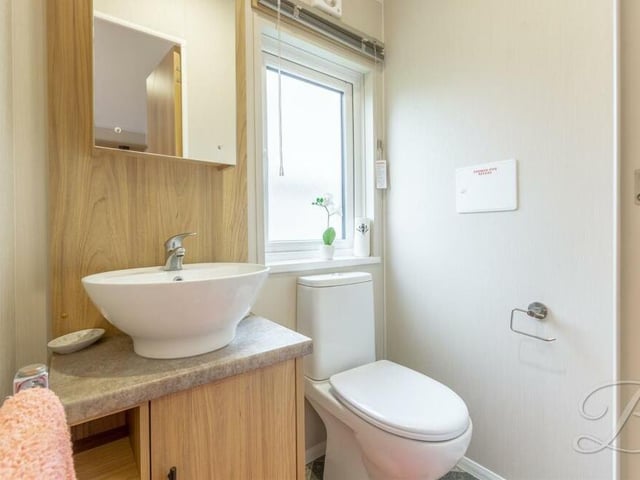 This is the private, two-piece en suite that belongs to the master bedroom. It is fitted with a hand wash basin and a low-flush WC.