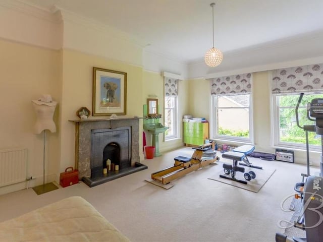 This bedroom has been converted into a gym or fitness room. It boasts a feature fireplace, its own hand wash basin and four windows overlooking the side and front of the house.