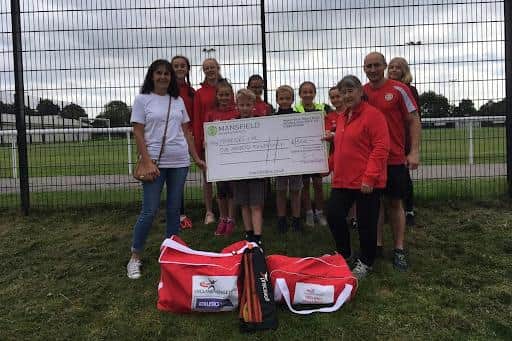 Members of Sutton Harriers, with their new equipment, receive the cheque from Mandy Whitten, products coordinator at Mansfield Building Society