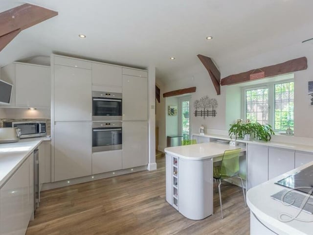 The kitchen is littered with integrated appliances that include two single electric fan ovens, a fridge freezer, a ceramic hob, cooker hood, wine cooler and dishwasher. Dual-aspect windows, to the front and rear, make it a bright space too, while double doors lead out to the garden.