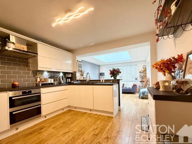 At the heart of the home lies the open-plan kitchen and family hub, which has been recently extended to include bi-fold doors, a relaxed snug or dining area, and a stunning ceiling lantern that floods the space with natural light