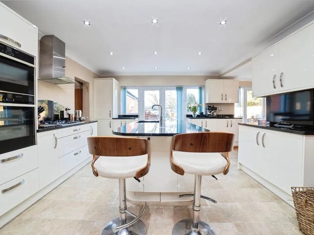 Two sets of patio doors flood the room with natural light and open directly to the rear garden, offering an easy indoor-outdoor flow ideal for entertaining or simply enjoying the view.