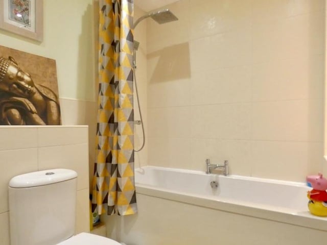 The bath in the family bathroom also has a square-bar shower over.