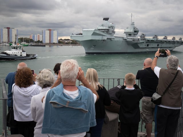 People wave from the Round Tower in Old Portsmouth as HMS Queen Elizabeth departs. Picture: Andrew Matthews/PA Wire
