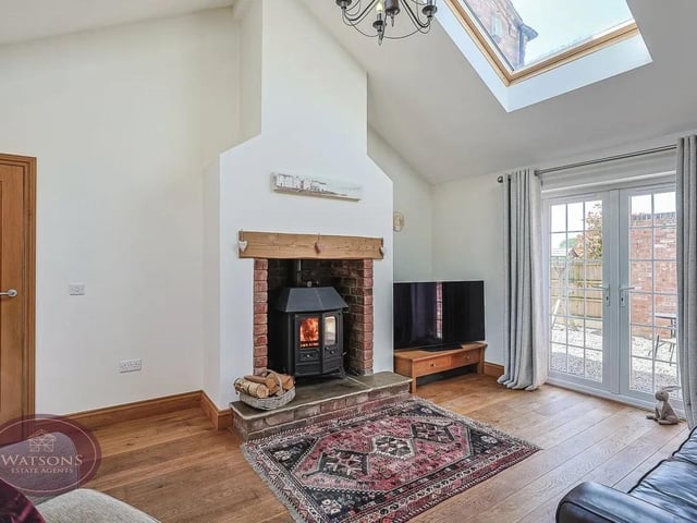 The lounge features an Inglenook fireplace with inset log burner which has been converted to a heating system, laminate wood flooring and two sets of French doors to the both sides.
