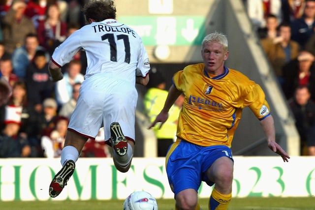 Paul Trollope is challenged by Bobby Hassell. Hassell made 33 league appearances for Stags during the 2003/04 campaign.