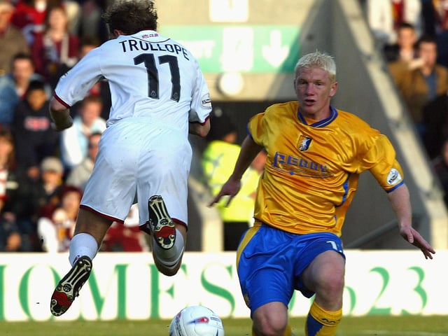 Paul Trollope is challenged by Bobby Hassell. Hassell made 33 league appearances for Stags during the 2003/04 campaign.
