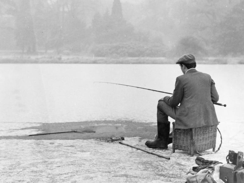Fisherman, Jeffery Gill fishes by the side of a lake in Clumber Park on 1st January 1962. He had to cut through six inches of ice before he began his day's fishing.