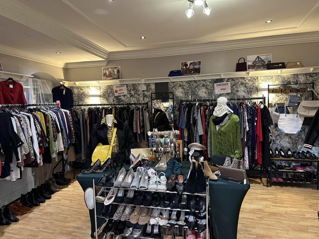 The store features ready-to-wear outfits, with clothing, shoes, and accessories on display as you enter.