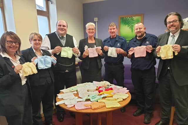 Co-op Funeralcare staff in Mansfield with baby clothes made from donated wool.
