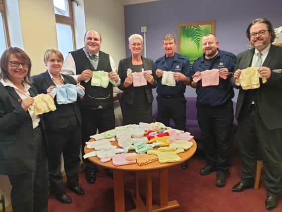 Co-op Funeralcare staff in Mansfield with baby clothes made from donated wool.