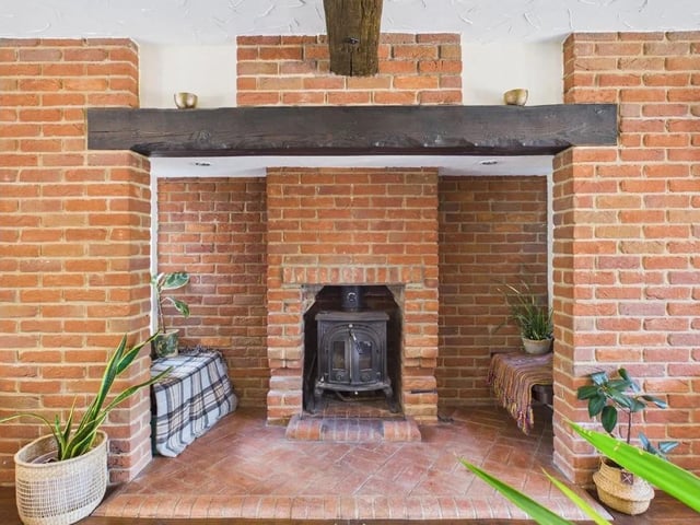 The lounge is centered around a feature inglenook fireplace with a stove burner, perfect for cosy evenings at home
