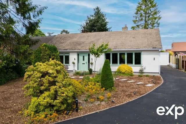 The property sits back from the road with an unforgettable first impression. A natural privacy screening of mature shrubs and trees frames a landscaped front garden with feature lighting.