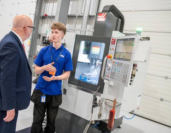 Mansfield MP Steve Yemm hears from Glenair UK apprentice Oliwier Puchacz about the machining process using a Haas CNC mini mill.