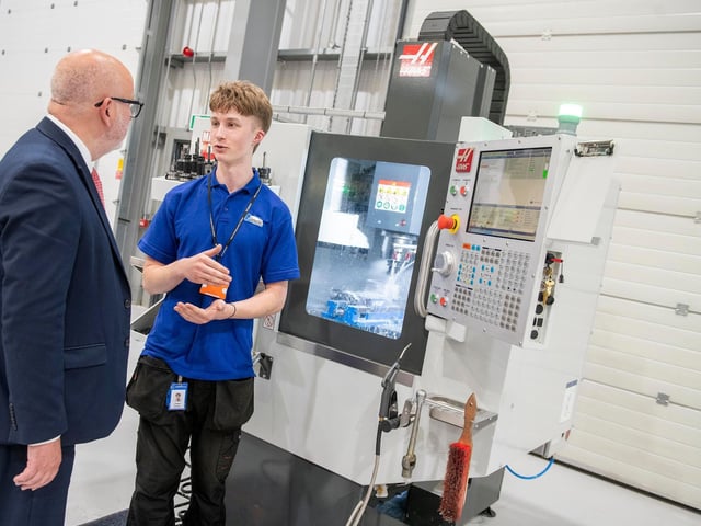 Mansfield MP Steve Yemm hears from Glenair UK apprentice Oliwier Puchacz about the machining process using a Haas CNC mini mill.