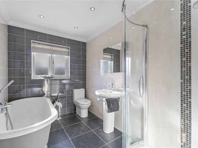 Free standing roll top bath, corner shower cubicle, WC and wash basin, full height tiled walls and flooring, double glazed frosted window to rear aspect and heated chrome towel rail.