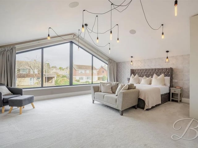 This generously sized master bedroom is a true retreat, featuring a stunning floor-to-ceiling feature window that bathes the space in natural light.