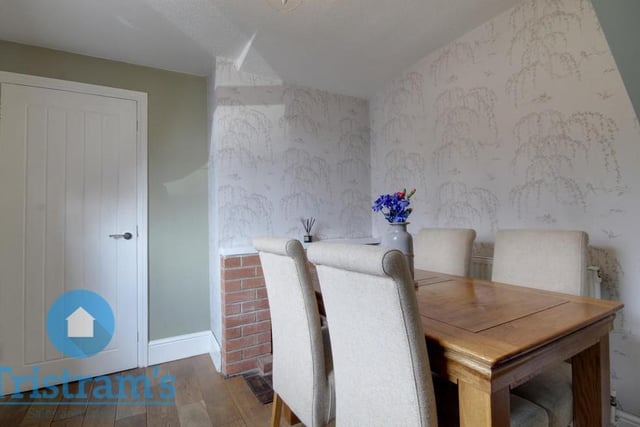 Here is the cottage's dining room, which is accessed via the living room and also leads directly to the kitchen. It has a fitted fireplace, wood flooring and a uPVC window to the front of the home.